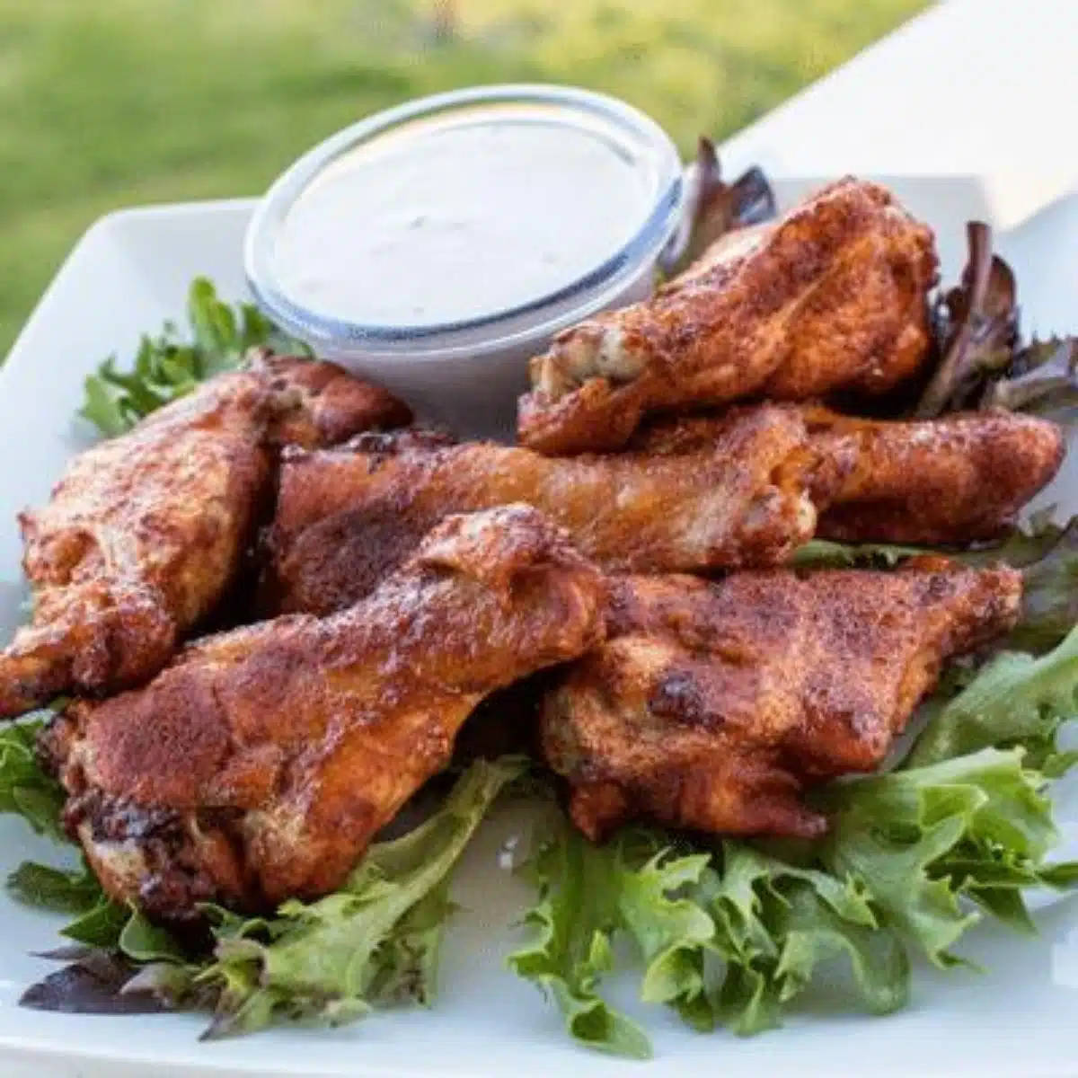 Square image of smoked chicken wings with a chipotle dry rub.