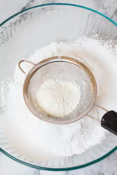 Process image 9 showing sifting powdered sugar and meringue powder.