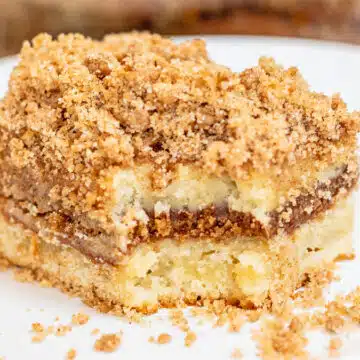 Wide image of slice of sour cream coffee cake on a white plate.
