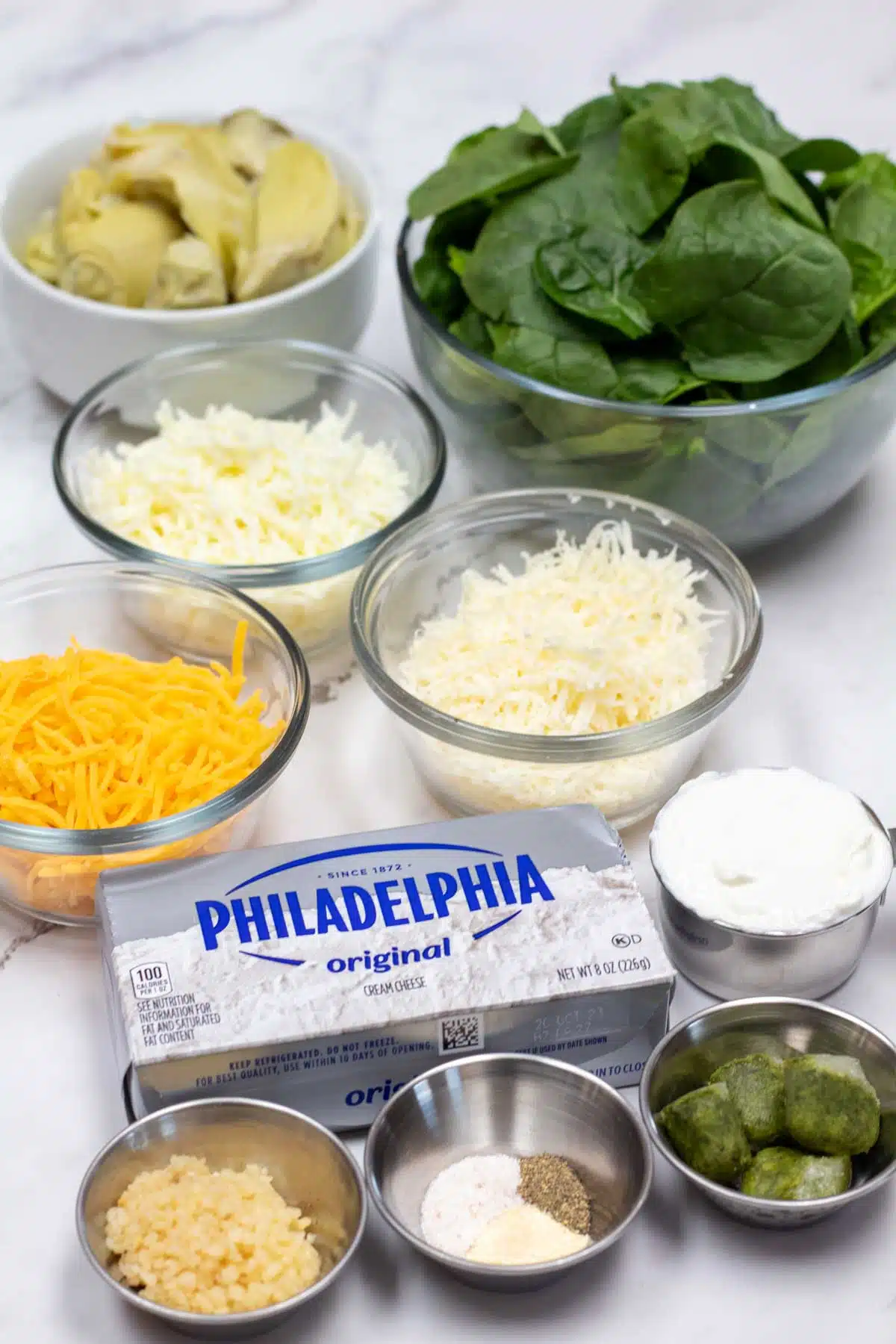 Tall image showing the needed spinach and artichoke dip ingredients.