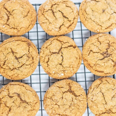Chewy molasses cookies baked on arranged on a baking sheet to cool.