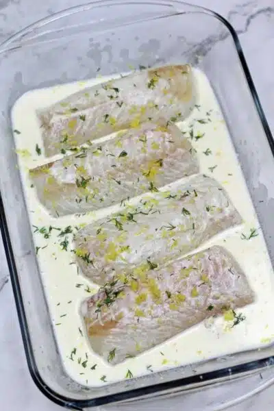 Process image 4 showing cod fillets topped with lemon zest.