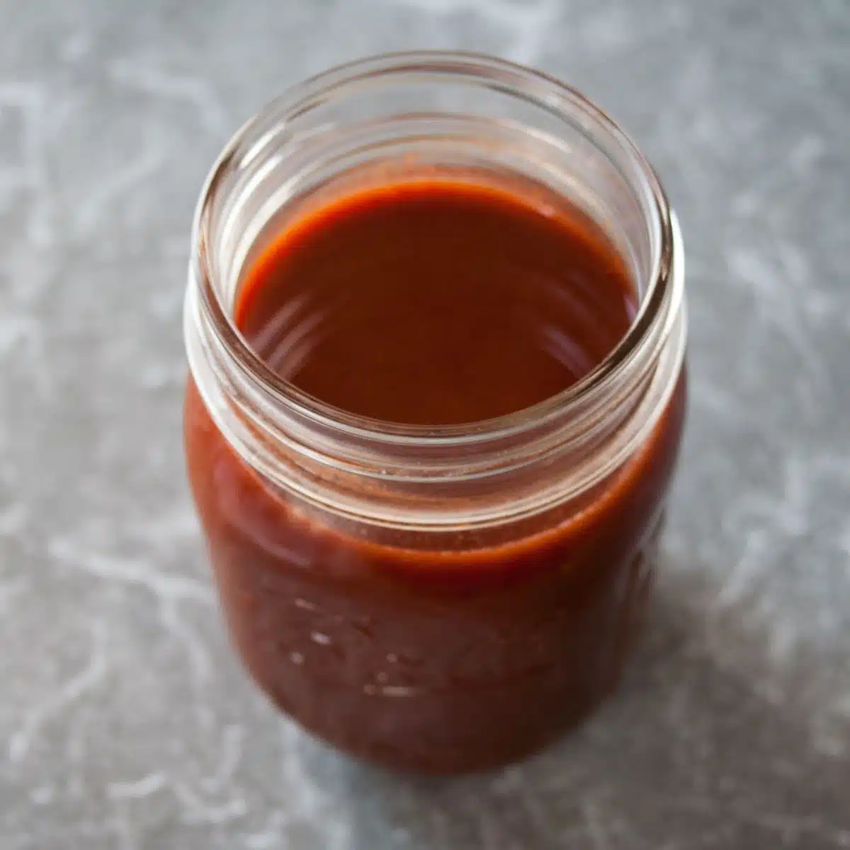 Square image of red enchilada sauce.