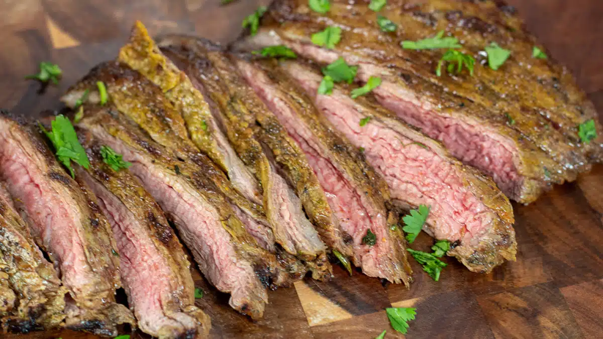 Wide image of sliced Arrachera steak on a cutting board.