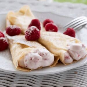 Square image of raspberry crepes.