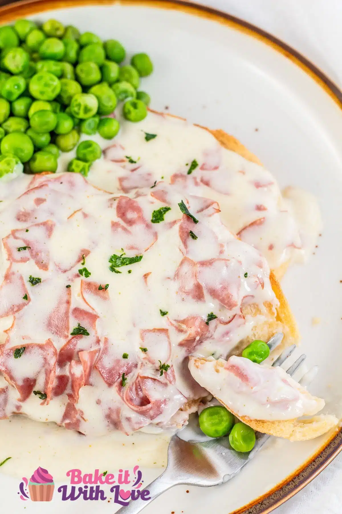 Creamed chipped beef on toast served with peas and a bite forked to the side.