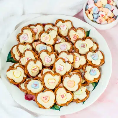 My easy Valentine's Day pretzel hearts are filled with melted white chocolate and topped with a Sweethearts conversation heart candy.