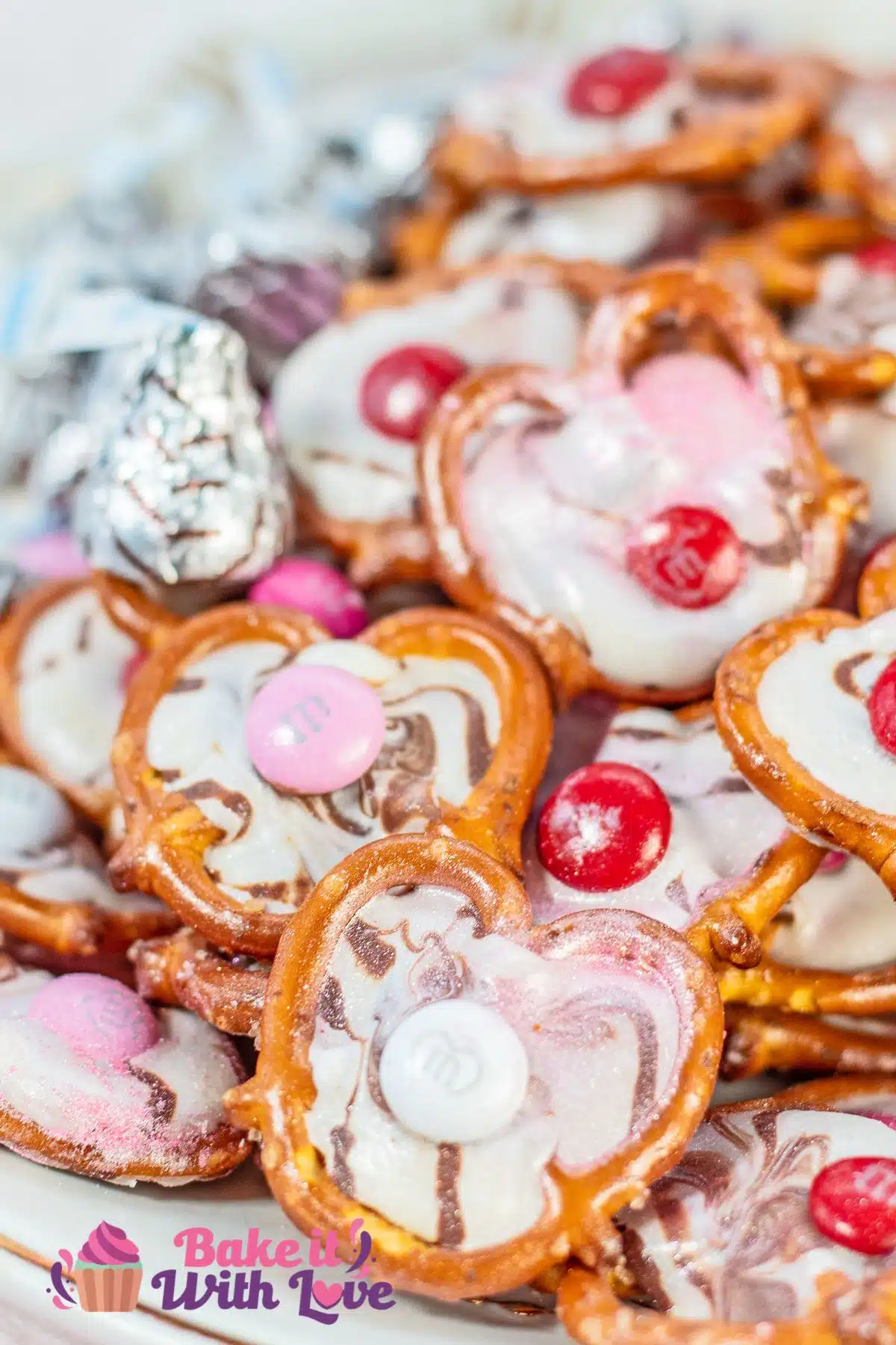 Valentine's Day pretzel hugs candies arranged on a serving plate with foil wrapped Hershey's hugs candies.