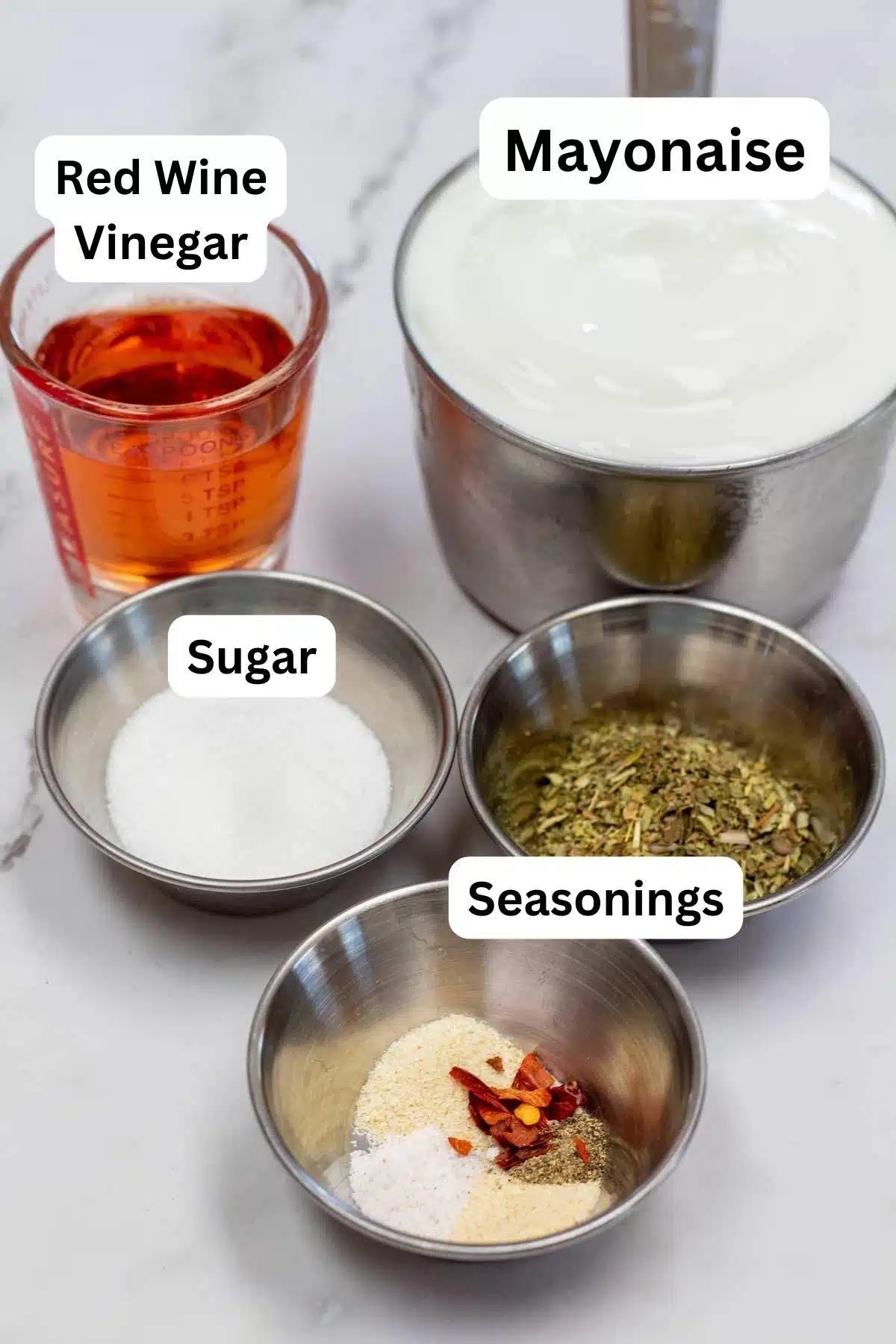 Tall image showing the ingredients needed to make the Italian dressing, with labels on each ingredient.