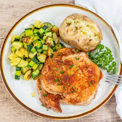 Best broiled pork chops recipe served with baked potato and sauteed zucchini.