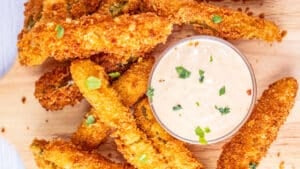 Easy Disney Parks homemade fried pickles copycat recipe including their zesty dipping sauce.
