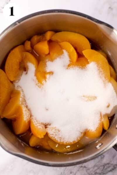 Paula Deen's Southern peach cobbler process photo 1 with the peaches and sugar added.