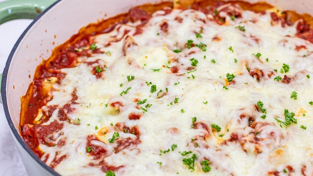 Easy, classic stuffed shells recipe with spinach and sausage baked in a shallow Dutch oven.