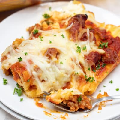 Easy stuffed manicotti with Italian sausage dinner recipe plated and garnished with parsley.