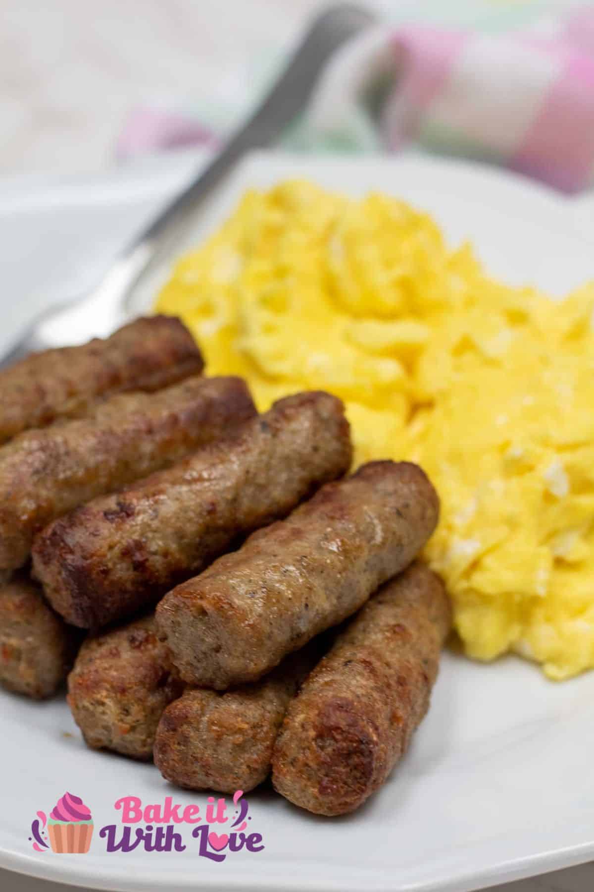 Tall image of air fried sausage links cooked from frozen on a plate with scrambled eggs.