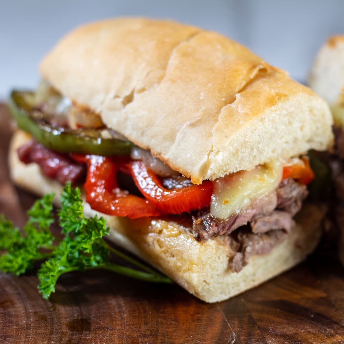 Philly cheese-steak sandwich on a cutting board.