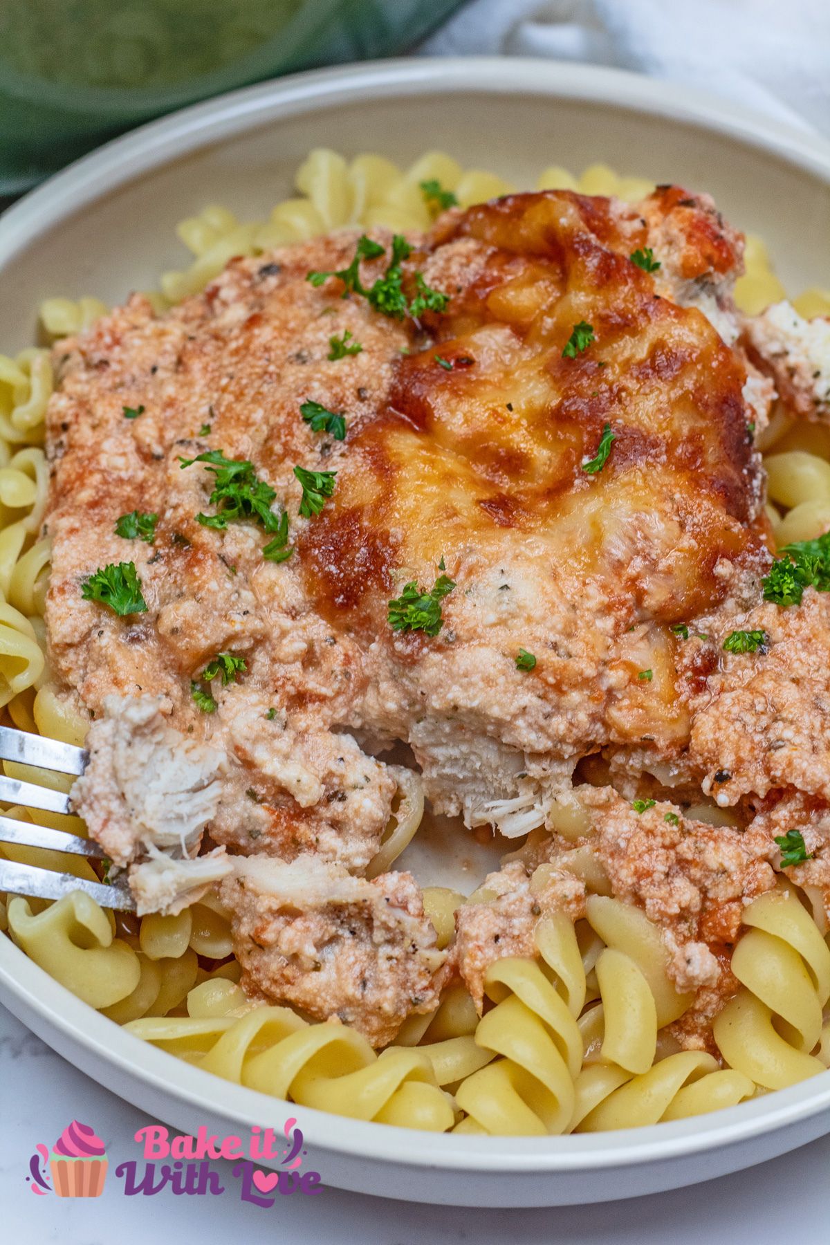 Tall overhead image of the plated baked ricotta chicken casserole served over pasta.