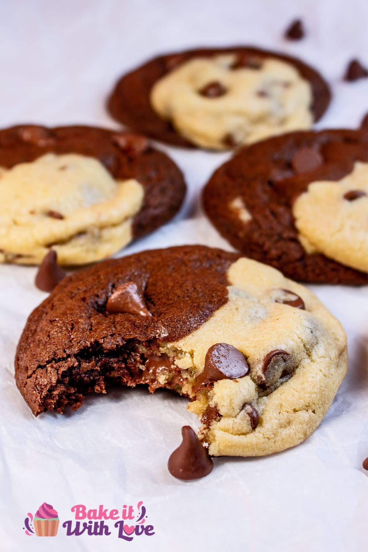 Vertical image of the brookies on a white sheet of parchment paper with the closest cookie having a bite taken from it.