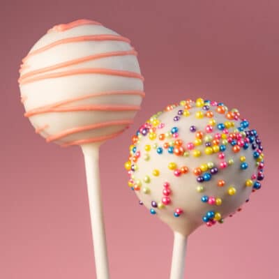 Best homemade cake pops recipe showing two cute cake pops on pink background.