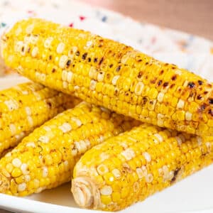 Square image of grilled corn on the cob.