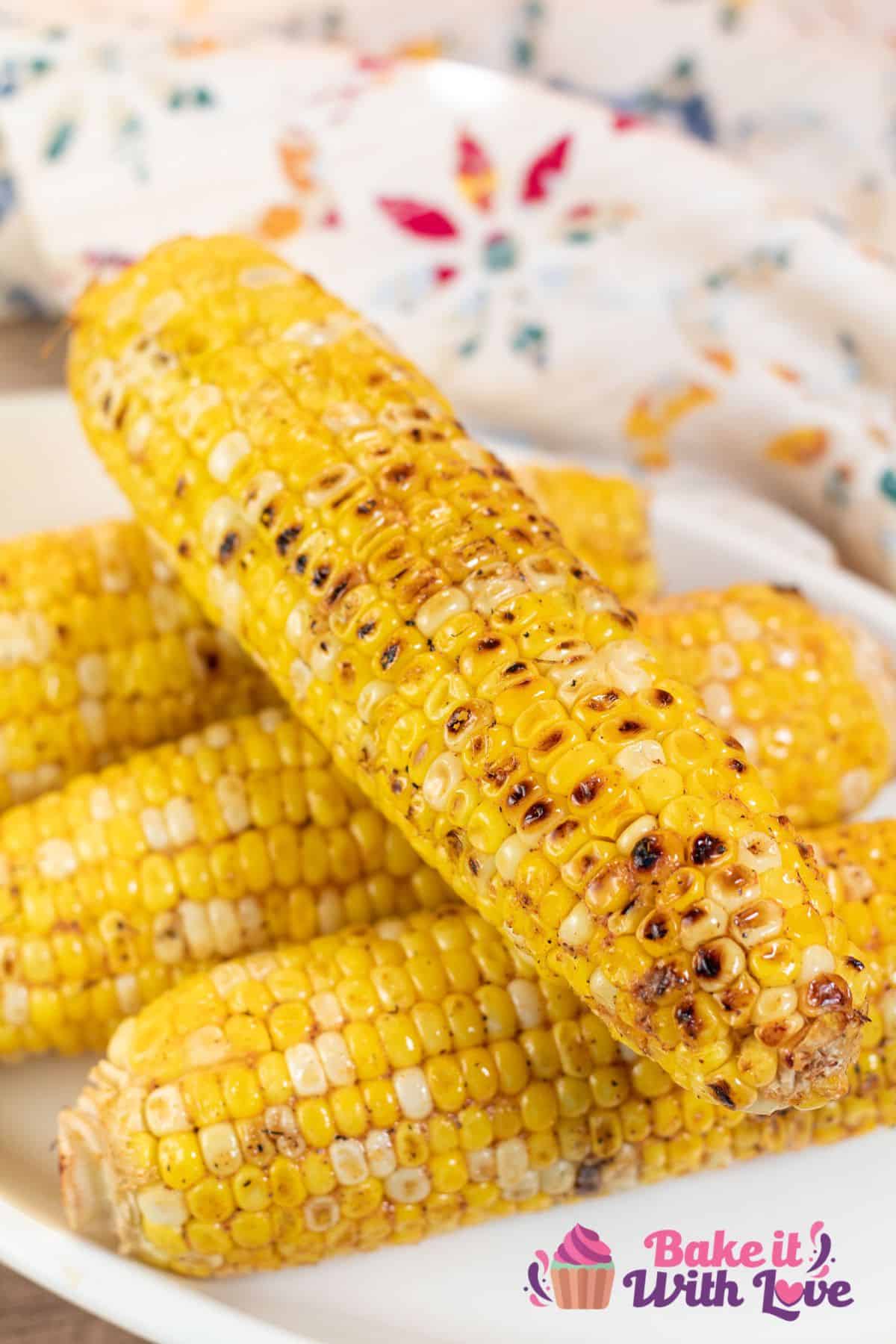 Tall image of grilled corn on the cob.