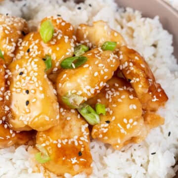 Wide image of honey sesame chicken and rice.