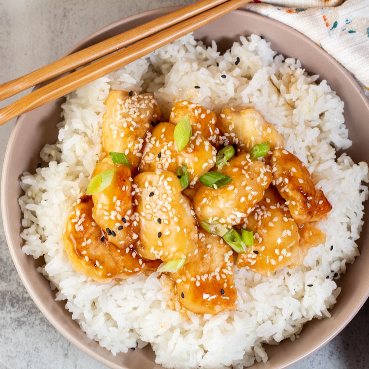 Square image of honey sesame chicken and rice.