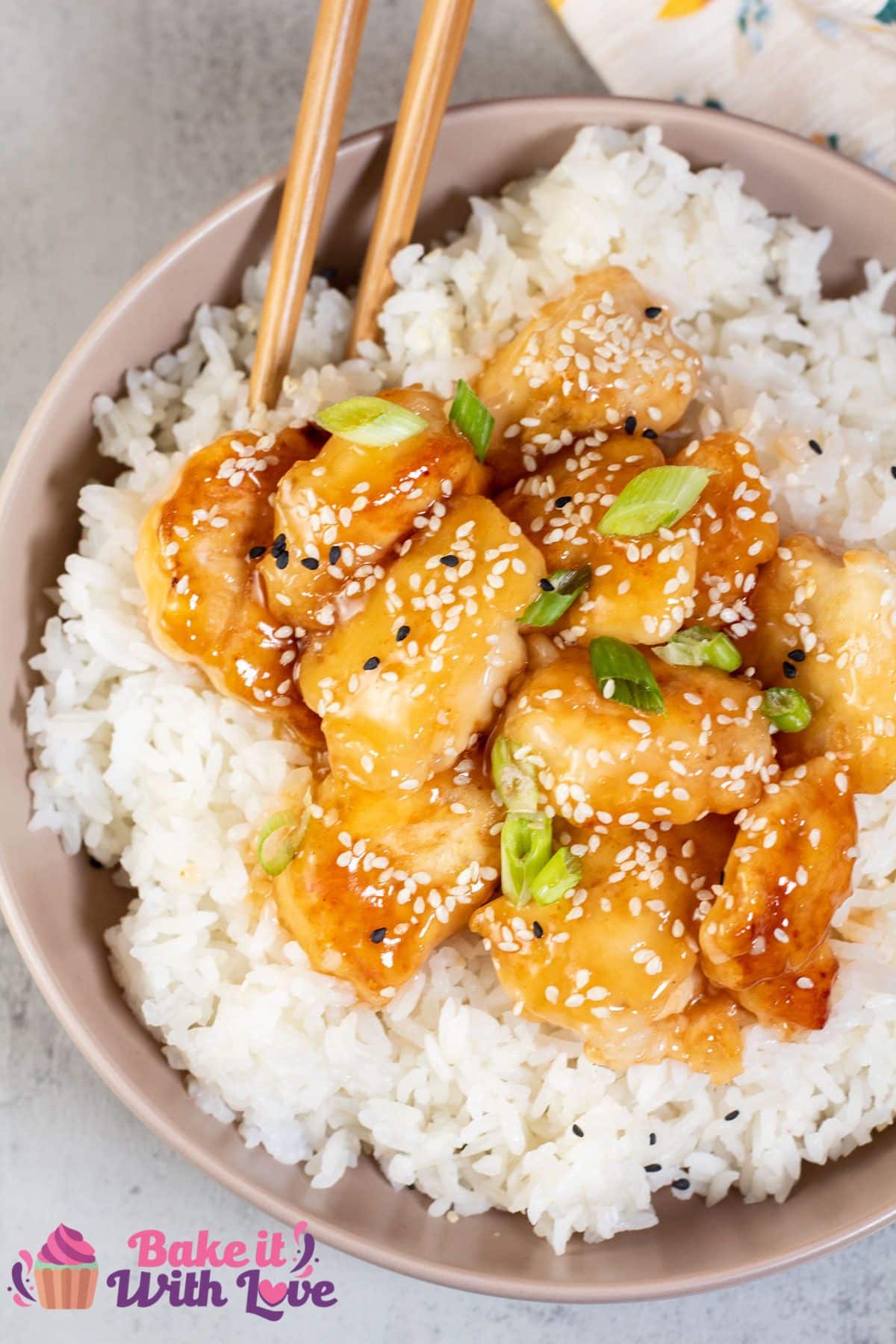 Tall image of honey sesame chicken and rice.