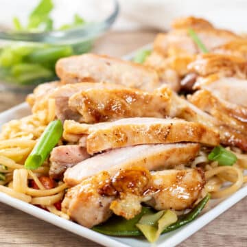 Wide image of Panda express teriyaki chicken on a white plate with lo mein.