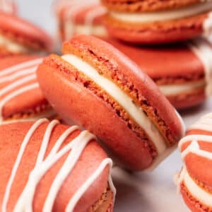 My tasty red velvet macarons randomly arranged with a closeup on one leaning against another.