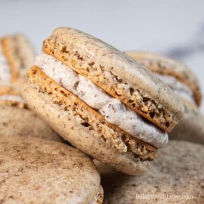 Rich, delicious cookies and cream macarons randomly assorted with one stacked on the others.