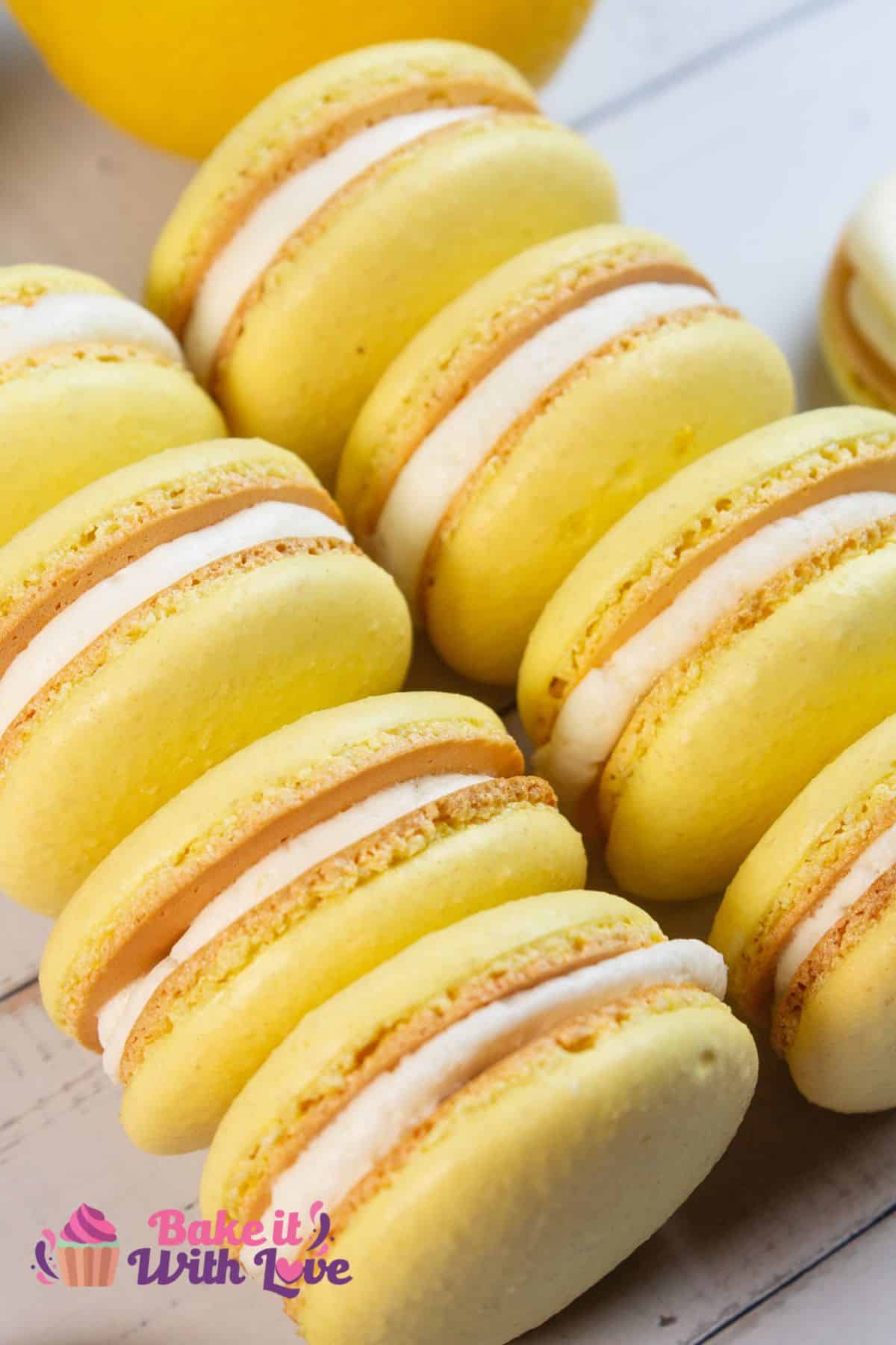 Angled view of two stacks of four lemon macarons on light background.