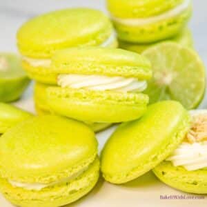 Tangy but sweet key lime macarons stacked on light background with an open one to the bottom right.