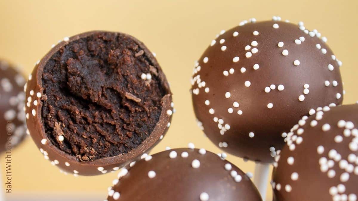 Tasty copycat Starbucks chocolate cake pops closeup view with one of the 5 cake pops showing the cake filling.