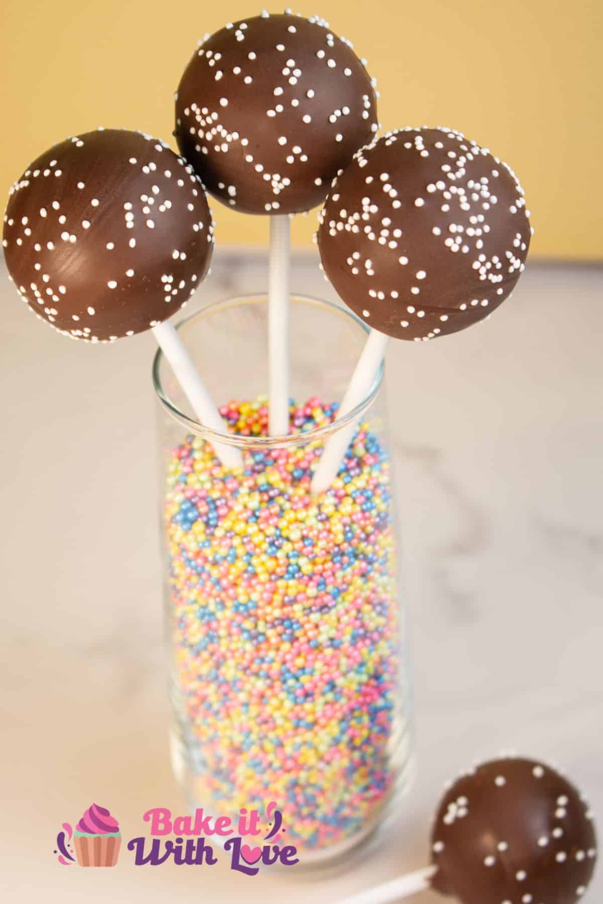 A jar full of three homemade Starbucks chocolate cake pops and one at the base of the jar.