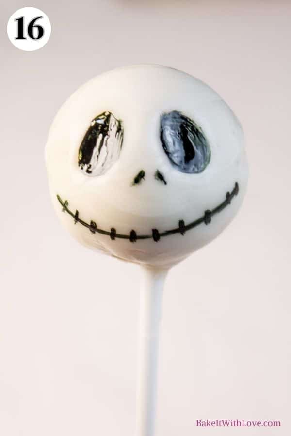 Halloween cake pops process photo 14 make Jack Skellington by filling in the eyes and drawing in the stitched mouth and small slit nostrils.