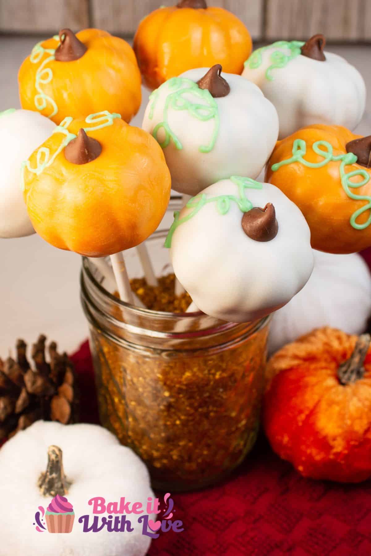 Tall image of pumpkin cake pops in a glass cup. 