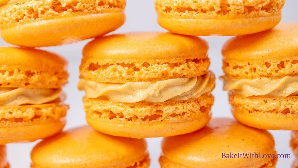 Horizontal image showing stacked pumpkin macarons.