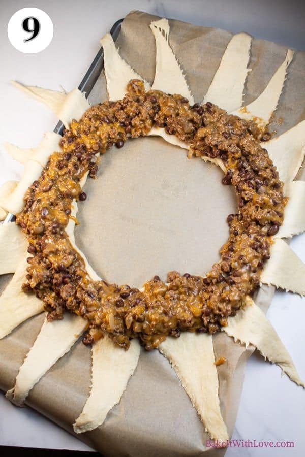 Spider taco ring process photo 9 crescent rolls arranged into overlapping circle on baking sheet with ground beef filling placed into the center.