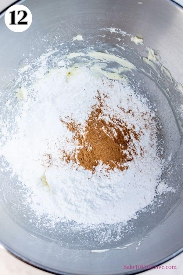 Apple pie macarons process photo 12 showing confectioners sugar and apple pie spice added to the butter in a metal mixing bowl. 