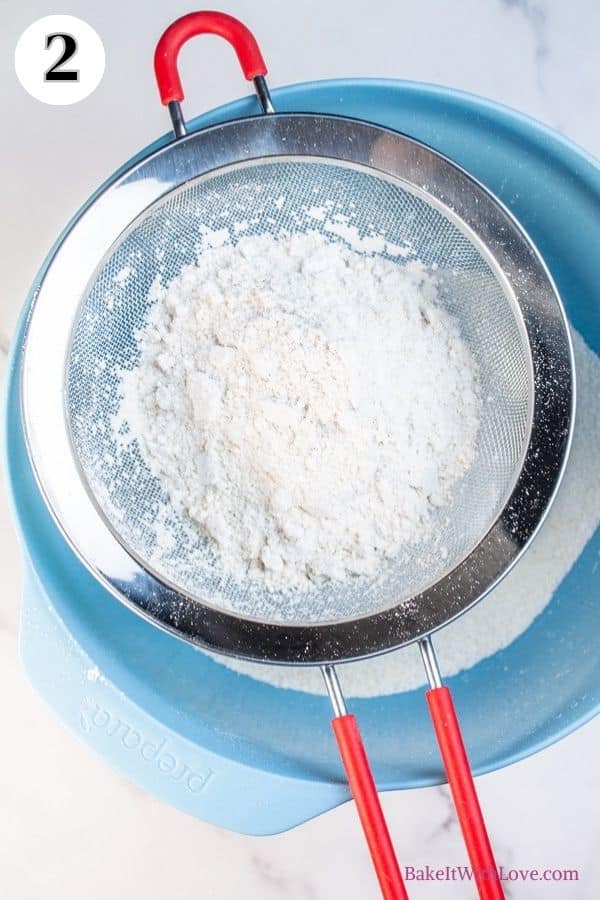 Apple pie macarons process photo 2 showing the flour mixture being sifted through a sieve into a mixing bowl. 