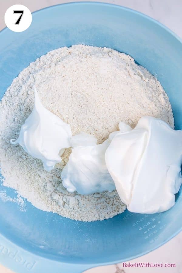 Apple pie macarons process photo 7 showing the flour mixture and some meringue in a mixing bowl. 