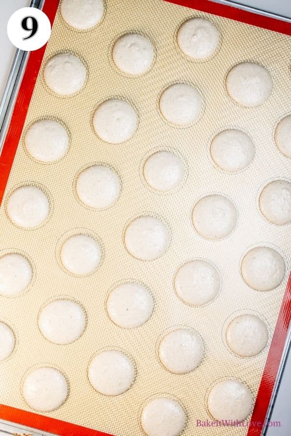 Apple pie macarons process photo 9 showing piped, unbaked macaron shells on a silicone baking mat. 