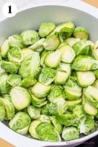 Crispy parmesan smashed brussel sprouts process photo 1 showing a pot full of halved brussel sprouts.