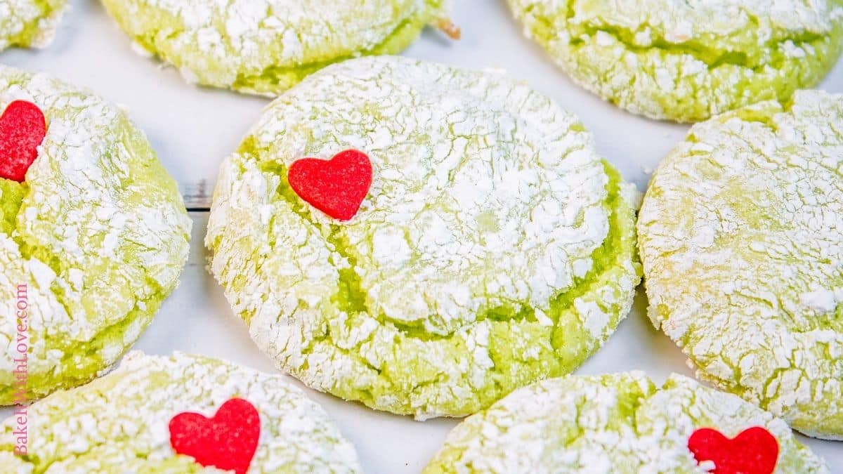 Wide image showing Grinch cookies set side by side with heart sprinkles. 