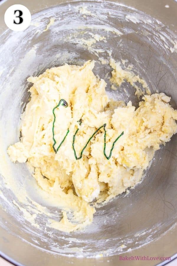 Grinch cookies process photo 3 showing cookie dough with green food coloring in a metal mixing bowl. 