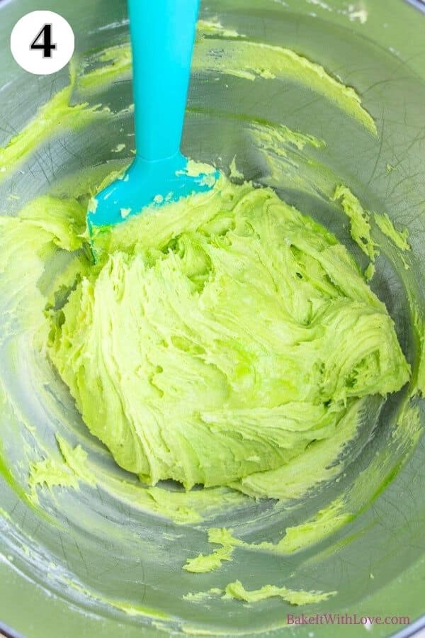 Grinch cookies process photo 4 showing the finished cookie dough in a metal mixing bowl with a rubber spatula sticking out of the dough. 