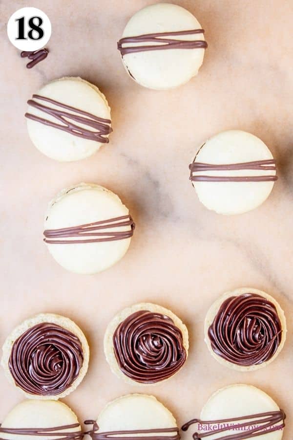 Mint chocolate macarons process photo 18 showing some fully assembled macarons on parchment paper alongside some that are covered with ganache. 