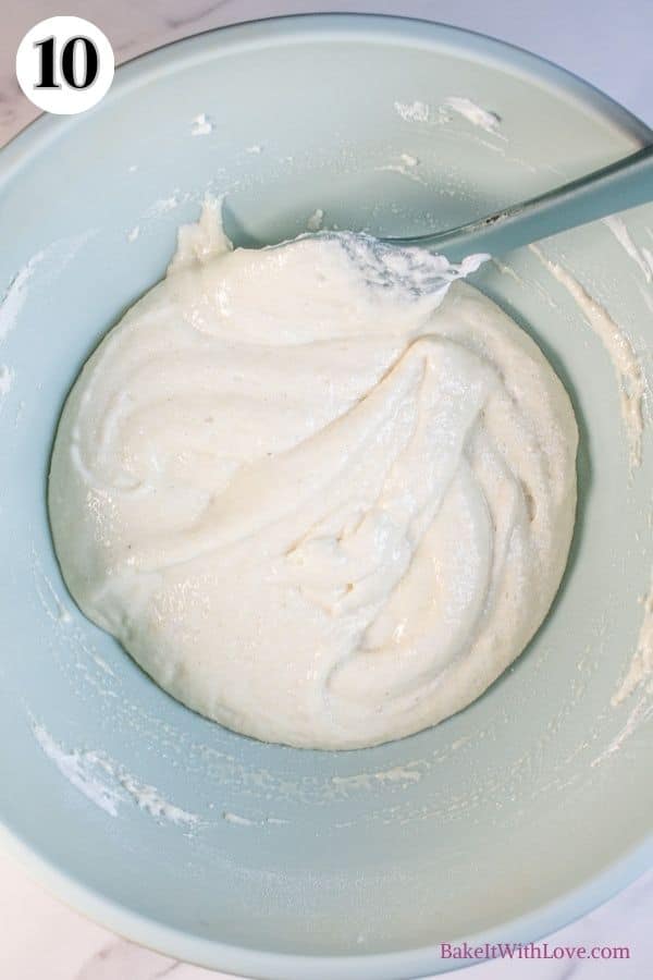 Peppermint macarons process photo 10 showing the finished macaron batter in a mixing bowl with a silicone spatula sticking out. 