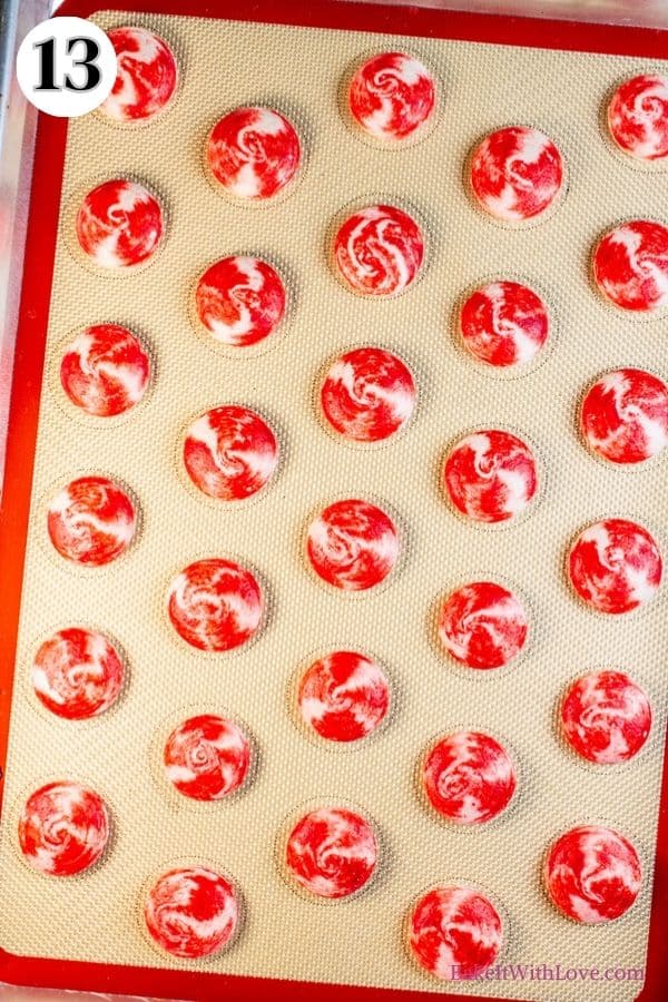 Peppermint macarons process photo 13 showing the baked macaron shells on a silicone baking mat. 